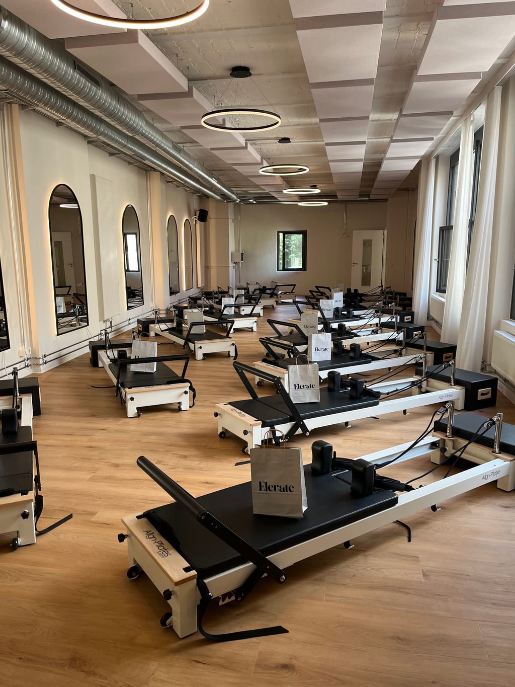 Elevate Pilates Reformer-Raum mit 15 Align-Reformern und großen Fenstern