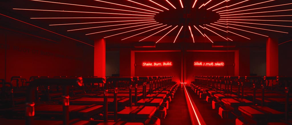 Roform Köln: Kursraum mit Reformer-Geräten in rotem Neonlicht am Ebertplatz