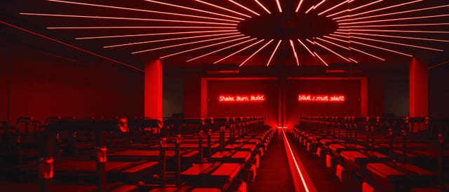 Roform Köln: Kursraum mit Reformer-Geräten in rotem Neonlicht am Ebertplatz