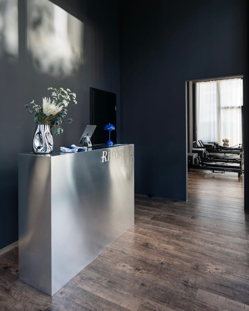 Empfangsbereich mit silbernem Front Desk im Reformer Loft München