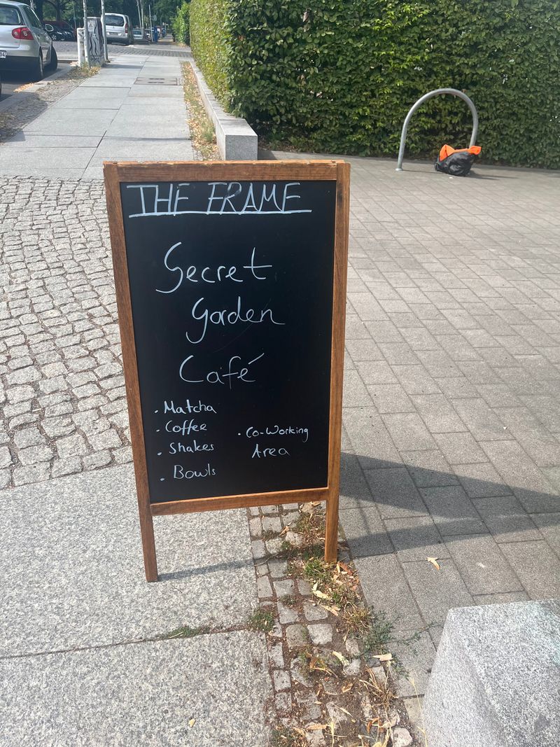 Kreidetafel vor The Frame Berlin: Secret Garden Café mit Matcha, Coffee, Shakes