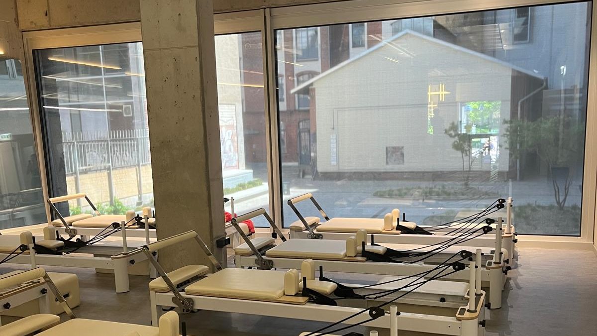 ZAYA Pilates Berlin: Weiße Reformer mit großen Fenstern zum Innenhof